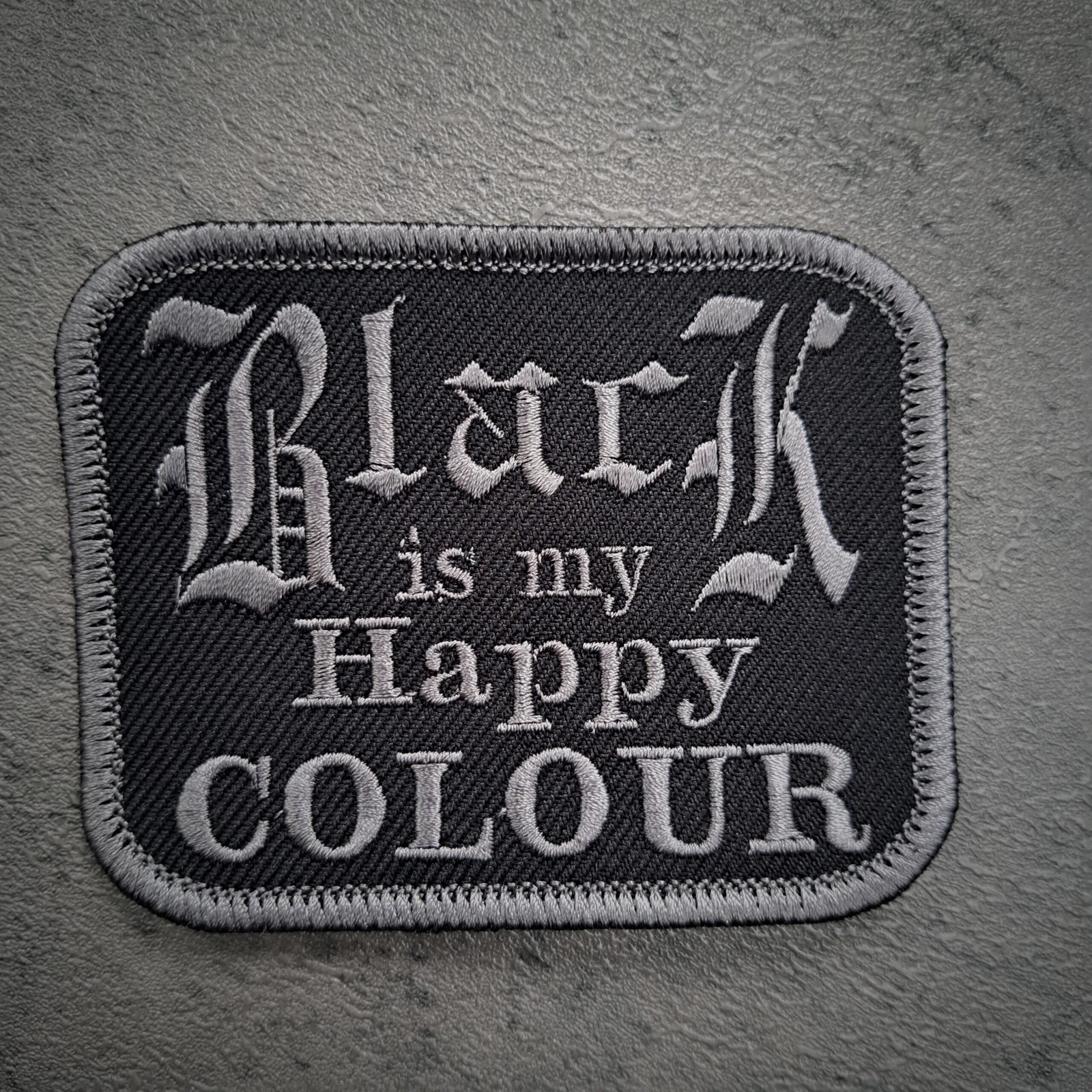 Black Is My Happy Colour Patch: A 9cm x 7cm rectangular gothic embroidered badge featuring grey Old English lettering on black twill.