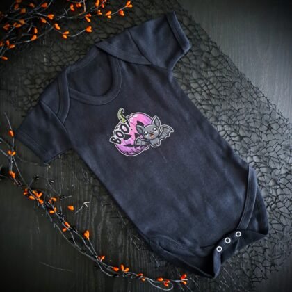 Black gothic baby vest with cute cartoon bat flying from a purple pumpkin with the word “Boo”, spooky alternative baby grow