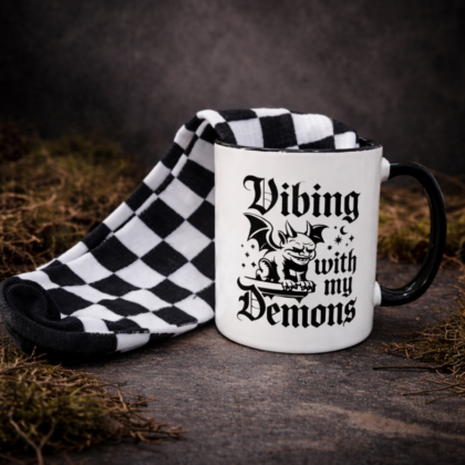 Gothic mug and black and white checkered socks gift set vibing with my demons design on stone background