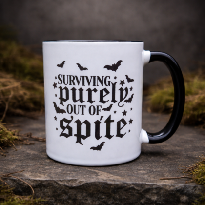 Gothic mug with “Surviving purely out of spite” text and bats design on moss stone background black handle right