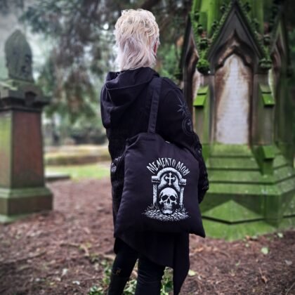 black goth tote bag with bold hex slut gothic lettering worn in atmospheric graveyard setting