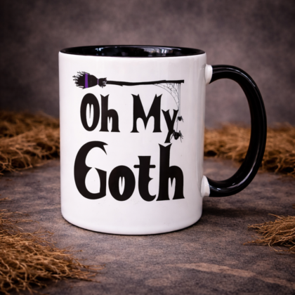 Oh My Goth gothic coffee mug with broom and spider web detail on black handle ceramic mug on dark textured background