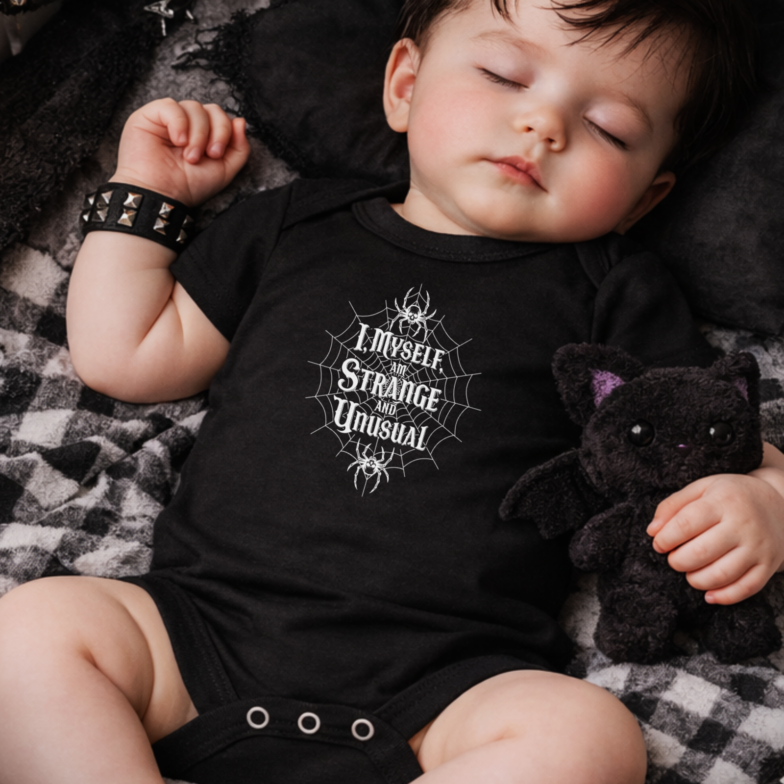 Close-up of gothic baby grow with strange and unusual spider web design