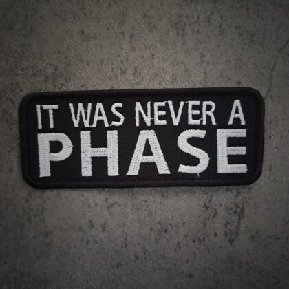 Black and white embroidered patch with text It Was Never A Phase
