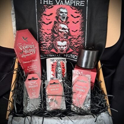 Full view of open Vampire Eternal Hunger gift box containing a black cotton tote bag, two-tone mug, bleeding pillar candle, red coffin incense box, stainless steel bat necklace, hanging bat earrings, and hematite bracelet surrounded by black shredded paper.