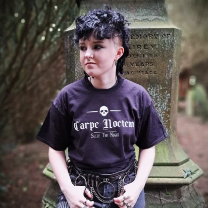 Carpe Noctem gothic t-shirt in black with white skull and Seize the Night lettering, modelled in front of a weathered gravestone.